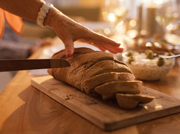 Mujer cortando hogaza de pan